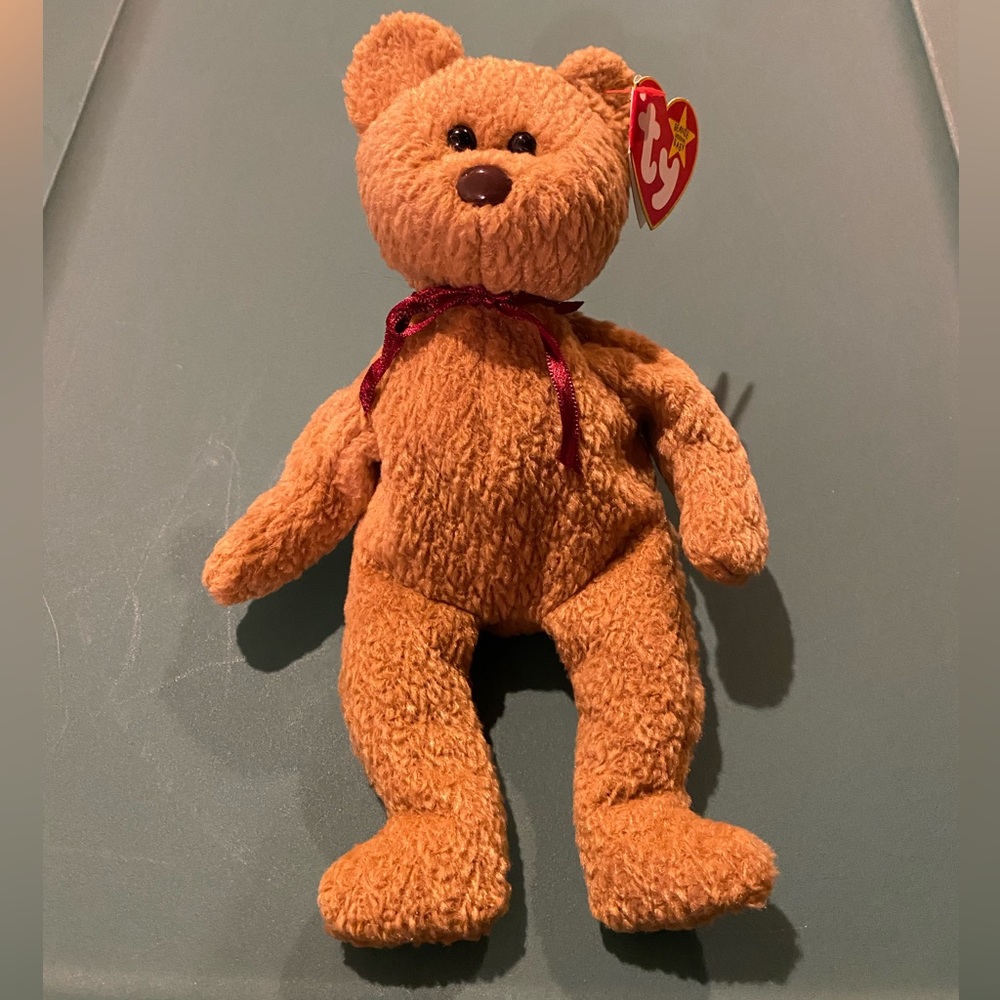 NWT Beanie Baby “Curly” bear, kept in collectible case.